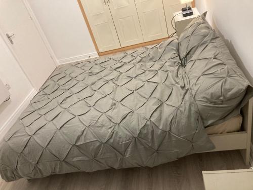 1 cama con edredón gris en una habitación en Stay cosy Apartment in Dublin City Centre, en Dublín