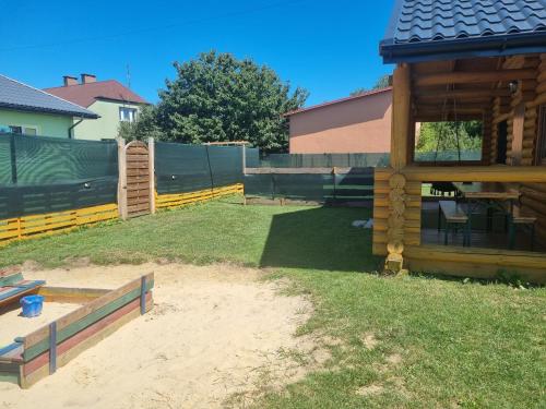 a backyard with a wooden fence and a house at Agroturystyka dom z bali całoroczny in Turbia