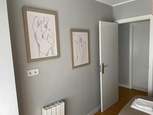 ein Zimmer mit zwei Zeichnungen an der Wand in der Unterkunft Arena Playa Gijón by Flowhome in Gijón