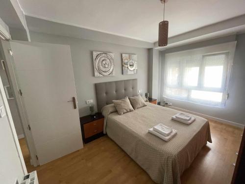 una camera da letto con un letto e due asciugamani di Arena Playa Gijón by Flowhome a Gijón