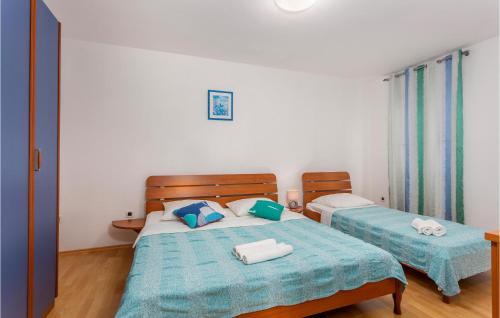 a bedroom with two beds with blue and white sheets at Beautiful Apartment In Pinezici With Wifi in Pinezici