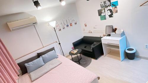 een slaapkamer met een bed en een bureau met een computer bij Ellen House in Seoul