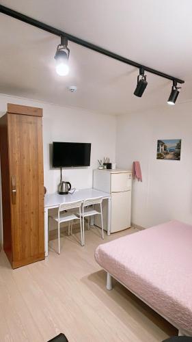 a bedroom with a desk and a bed and a television at Ellen House in Seoul