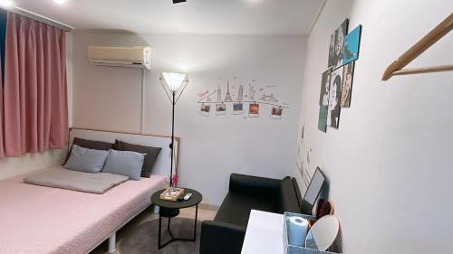 a small room with a bed and a chair at Ellen House in Seoul