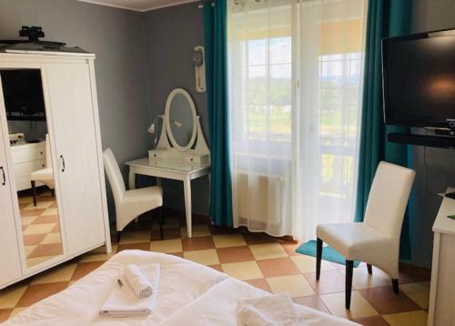a room with a bed and a mirror and a vanity at ANNABERG Polanica Zdrój in Polanica-Zdrój