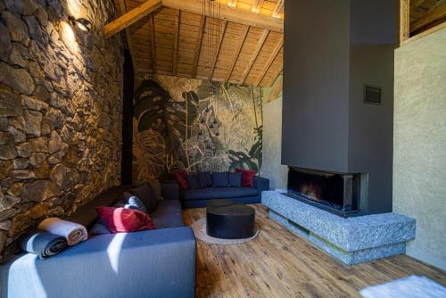 a living room with a couch and a fireplace at Le 11 des Bouchaux, Gîte d'exception in La Bresse