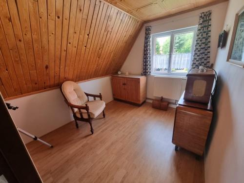 Habitación en el ático con silla y ventana en Stuga Horni Blatna, en Horní Blatná