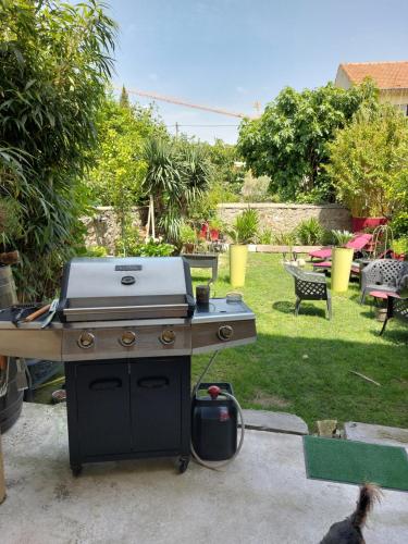 een barbecue in een achtertuin met een tuin bij LA MAISON DU BIEN ETRE o in Alès