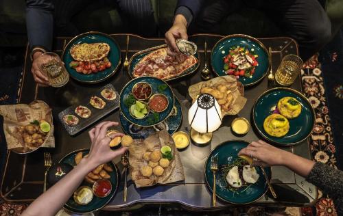 a group of people sitting around a table with food at The Coach Hotel Sukhumvit - Asok BTS Bangkok in Bangkok