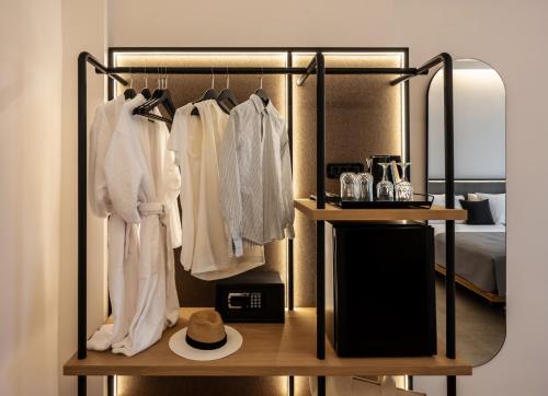 a hotel room with a rack of clothes and a bed at Chora Suites, Premium Key Collection in Skiathos