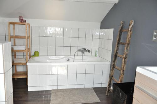 a white tiled kitchen with a sink and a ladder at Gîte l' Ancien Four - De Bakoven in Lessines