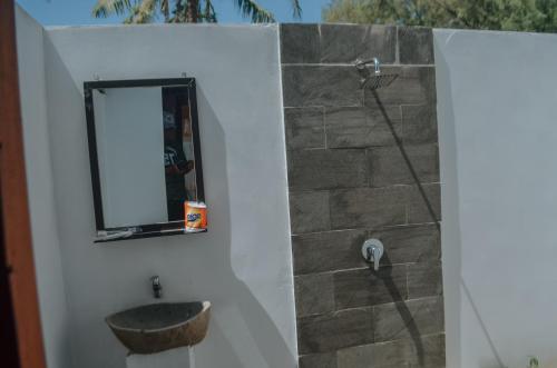 ein Bad mit einem Waschbecken und einem Spiegel in der Unterkunft Laba Laba Bungalow in Gili Meno