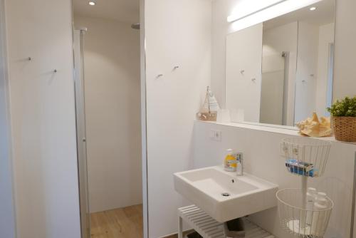 a white bathroom with a sink and a mirror at Baabe Villen Ensemble FeWo 34 Pura in Baabe