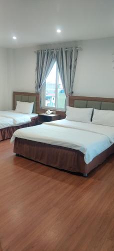 a bedroom with two beds and a large window at Khách sạn Phúc Thành in Hanoi