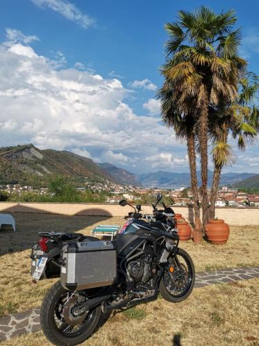 a motorcycle parked in a field next to palm trees at B&B La Fenice sul Lago in Villongo SantʼAlessandro