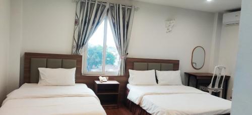 2 camas en una habitación con ventana en Khách sạn Phúc Thành en Hanoi