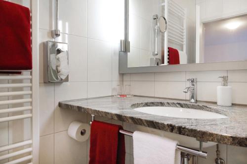 a bathroom with a sink and a mirror and towels at Hotel-Restaurant Roter Ochsen in Lauchheim