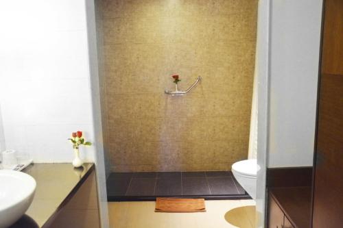 y baño con ducha, aseo y lavamanos. en Ashraya International Hotel, en Bangalore