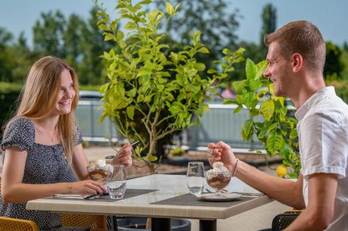 a man and a woman sitting at a table with wine glasses at Holiday Resorts in Balatonszárszó