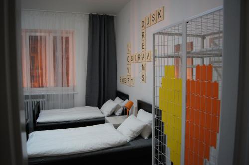 オストラヴァにあるApartmany Ostravaのベッド2台とテーブルが備わる小さな客室です。