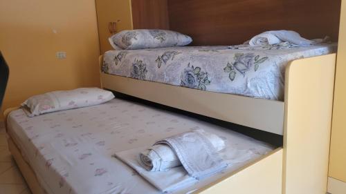 two beds in a room with towels on them at Charming Apartment Lushnje in Lushnjë