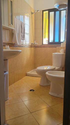 LushnjëにあるCharming Apartment Lushnjeのバスルーム(トイレ2つ、シンク付)