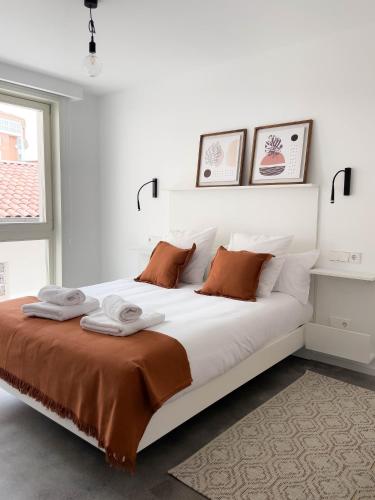 a bedroom with a large white bed with two pillows at HomeSanGil in Burgos
