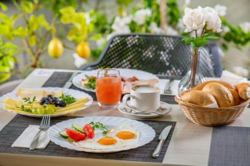 a breakfast table with eggs and bread and juice at Holiday Resorts in Balatonszárszó