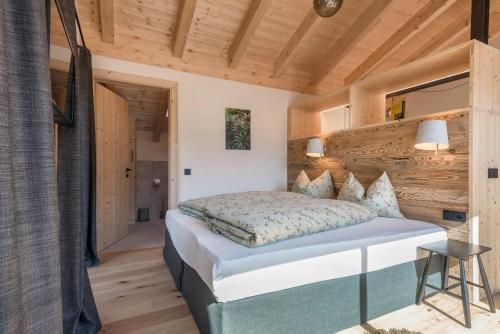 een slaapkamer met een bed en een houten muur bij Apartment Reguz in Villnoss