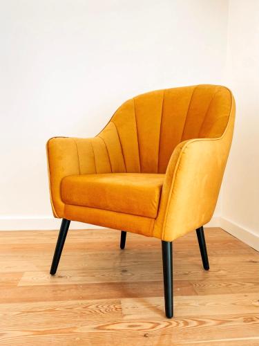 an orange velvet chair sitting in a room at Preia-Mar Duplex Setúbal Miradouro in Setúbal