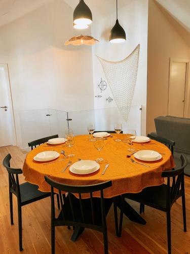 a dining room table with chairs and a yellow table cloth at Preia-Mar Duplex Setúbal Miradouro in Setúbal
