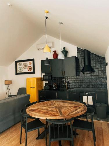 a kitchen and dining room with a wooden table at Preia-Mar Duplex Setúbal Miradouro in Setúbal