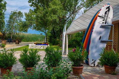 a large surfboard next to a house with plants at Holiday Resorts in Balatonszárszó