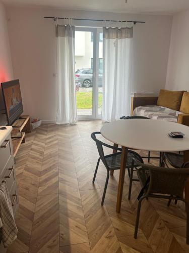 a living room with a table and a couch at Uroczy apartament z ogrodem in Rumia