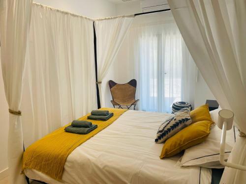 a bedroom with a large bed with yellow pillows at AZUL PORTMÁN – DESIGNED FOR GROUP in Portman