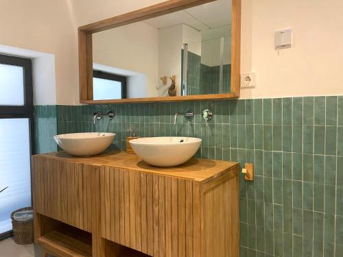 a bathroom with two sinks on a wooden counter with a mirror at AZUL PORTMÁN – DESIGNED FOR GROUP in Portman