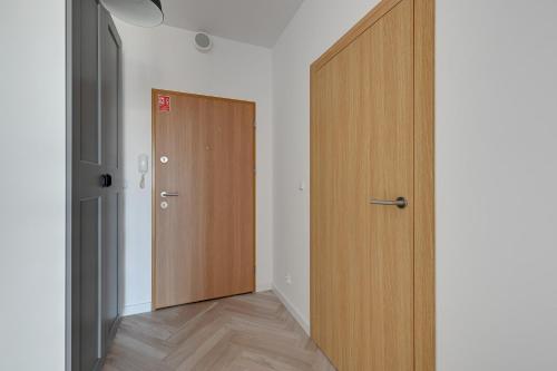 einen leeren Flur mit einer Holztür in einem Zimmer in der Unterkunft Bastion Wałowa Comfort Apartments in Danzig