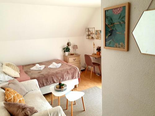 a small bedroom with a bed and a table at Chez Romy - studio équipé avec wifi - proche plage Deauville in Tourgeville