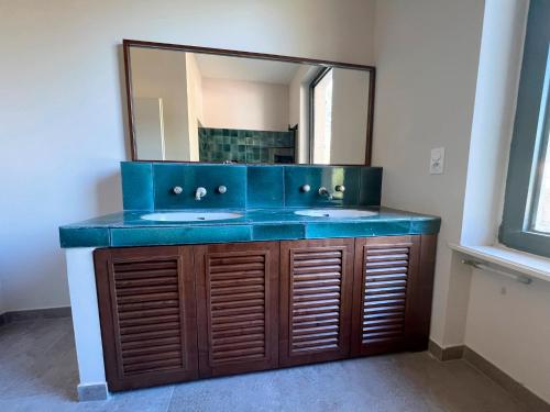 La salle de bains est pourvue de 2 lavabos et d'un miroir. dans l'établissement Bienvenue au Mas du Roulier, villa provençale avec vue hypnotique sur la chaine des Puys, à Thiers