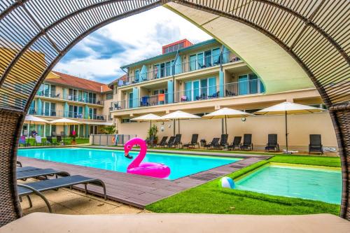a pool with a pink swan in front of a building at Holiday Resorts in Balatonszárszó