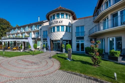 a building with a clock in front of it at Holiday Resorts in Balatonszárszó