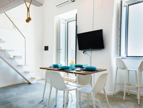 a dining room with a table and chairs and a tv at Dimora Cavour in Amantea