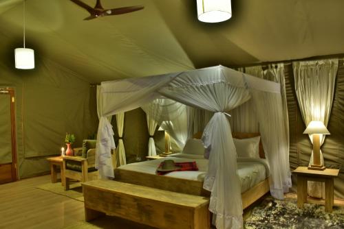 a bedroom with a canopy bed in a tent at Mara Maisha Camp in Talek