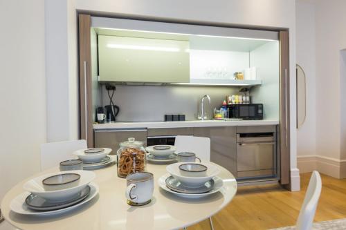 a kitchen with a table with dishes on it at The Dorset Suite - Stylish New 1 Bedroom Apartment In Marylebone in London