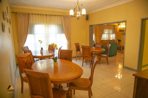 a dining room with two tables and chairs and a dining room at CWEZI BY THE LAKE in Entebbe