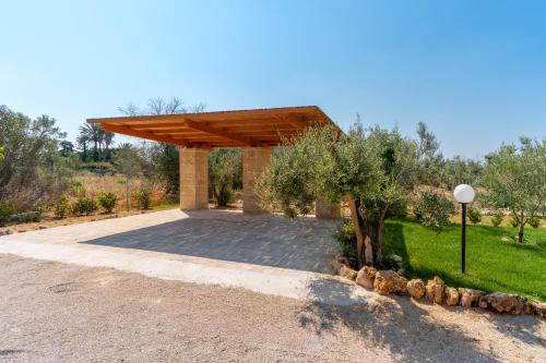 a pavilion with a wooden roof on a road at Dependance di Villa Dea by BarbarHouse in Matino