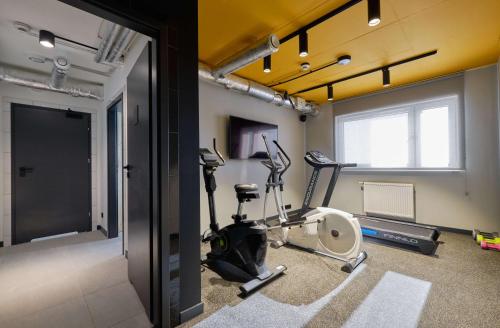 a gym with exercise equipment in a room at Arche Hotel Wrocław Airport in Wrocław