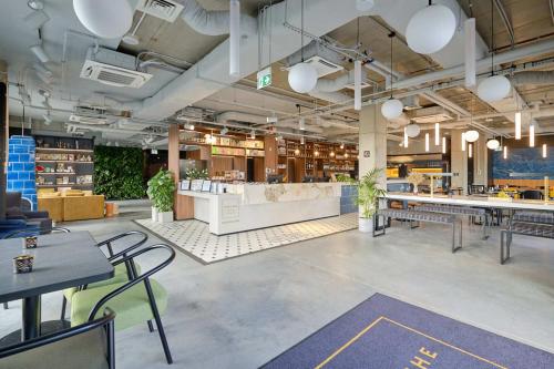 a restaurant with tables and chairs in a room at Arche Hotel Wrocław Airport in Wrocław