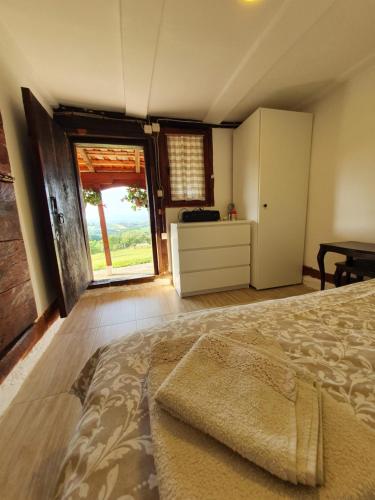 a bedroom with a bed and a large window at Vajat Orašac in Arandjelovac