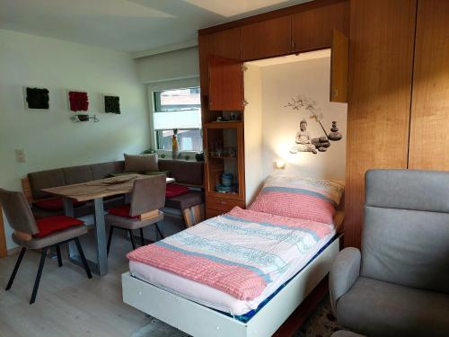 サンクト・ジョアン・イン・チロルにあるApartement GYARMATYのベッドとダイニングルームが備わる小さな客室です。